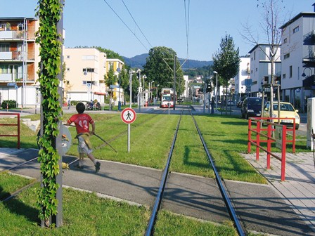 Grass grows between tram tracks in an urban environment